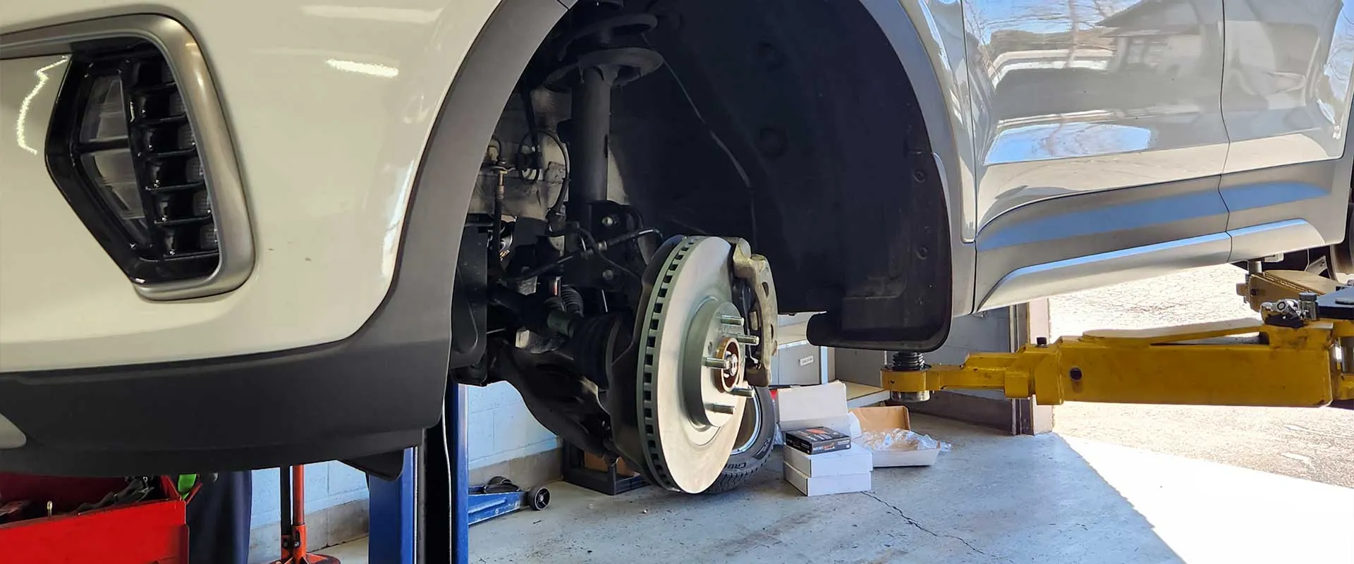 Car on lift with exposed brake disc.