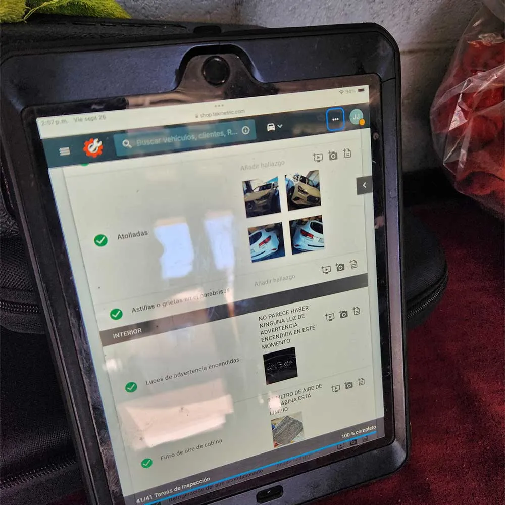 Tablet displaying vehicle inspection checklist with images.