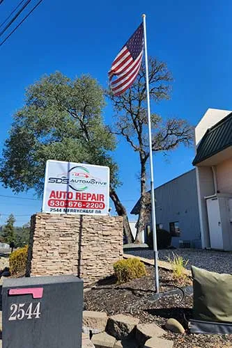 Auto repair shop with American flag and sign