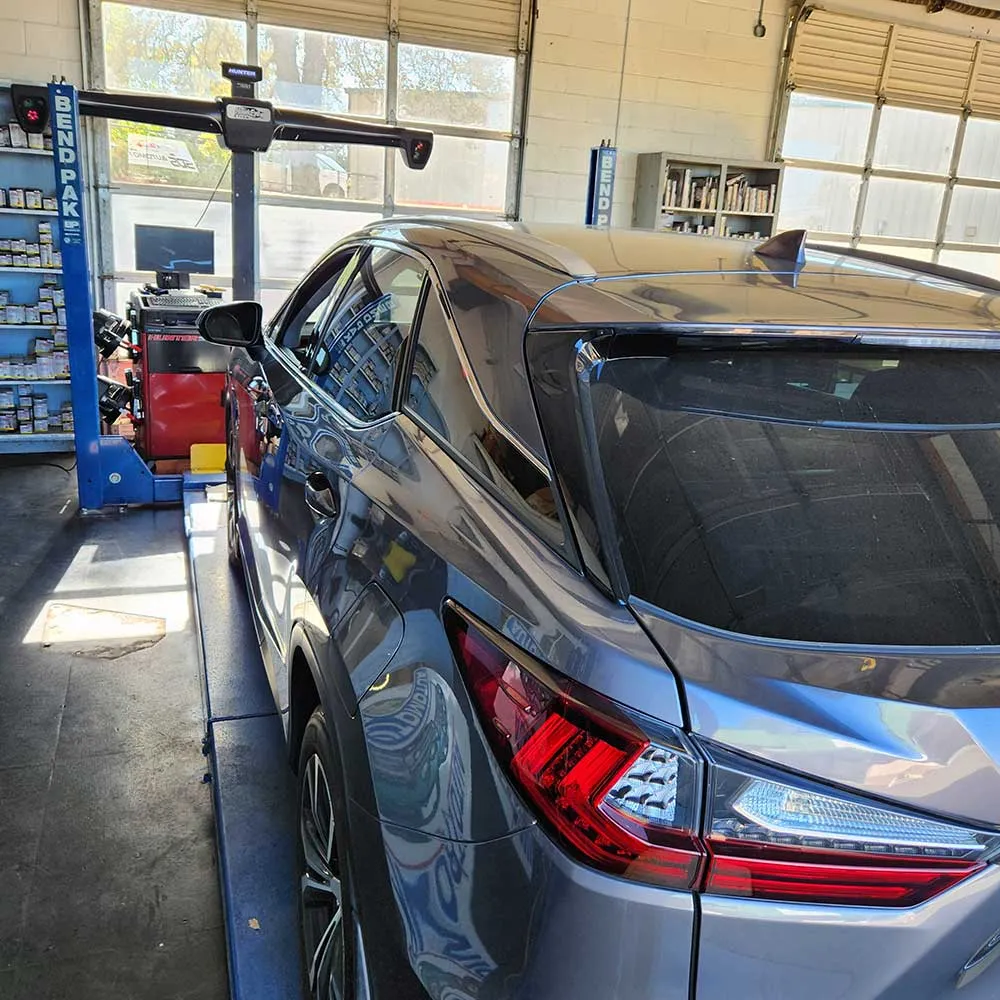 Car on service lift in auto repair shop.